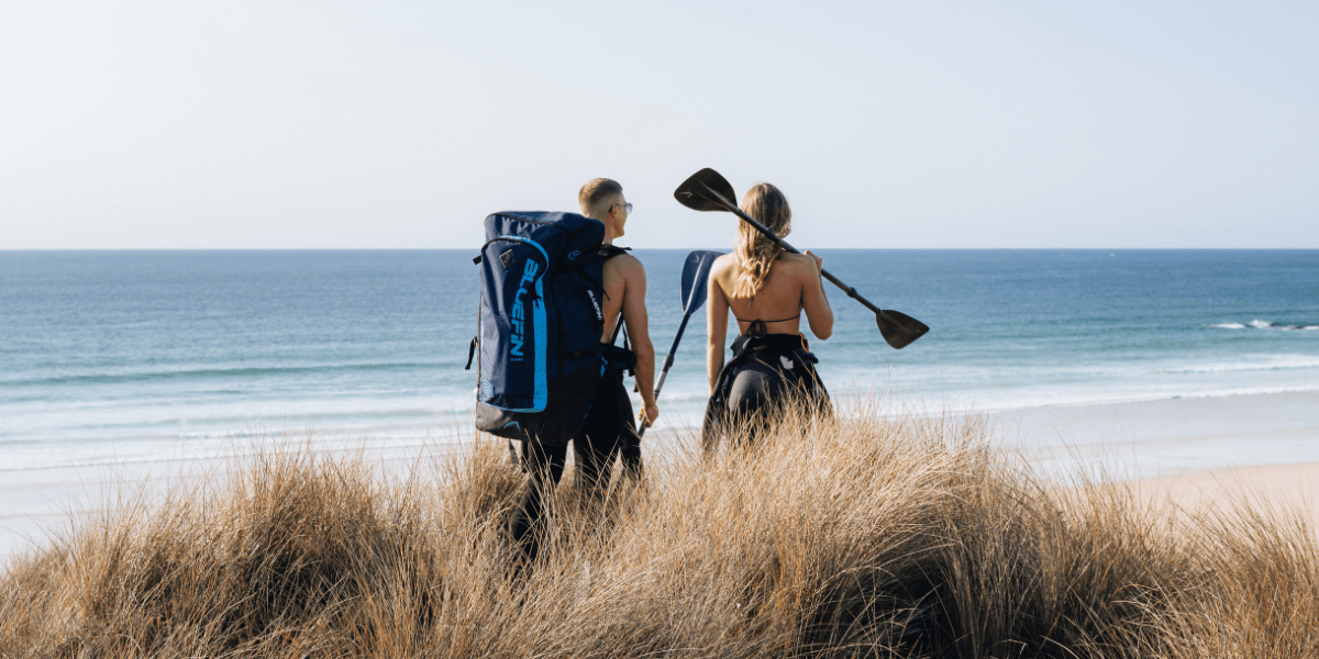 two people getting ready to start paddleboarding