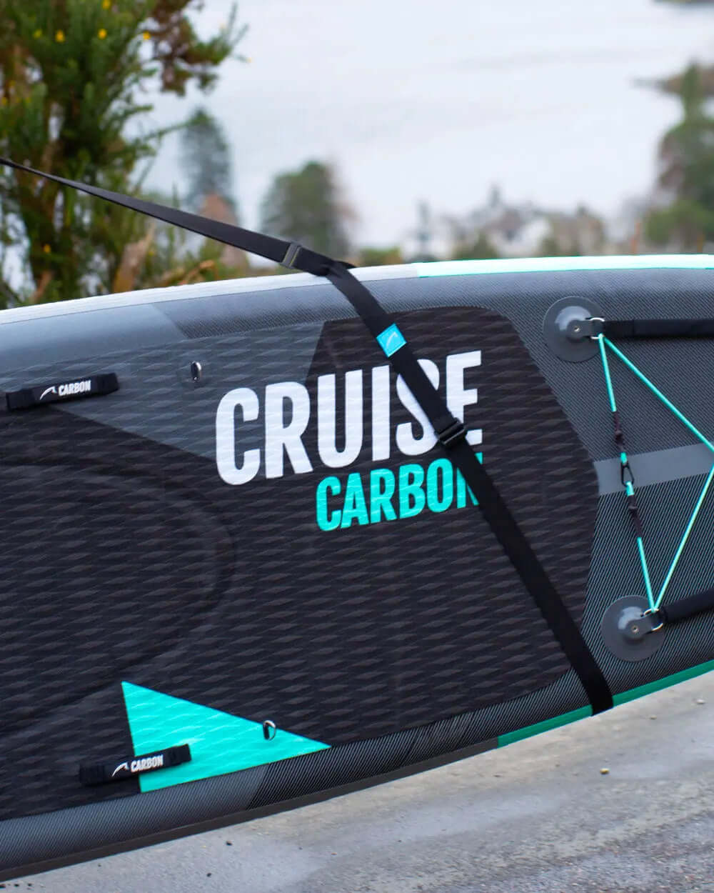 Inflatable paddleboard with textured deck, center fin, and straps for securing during transport