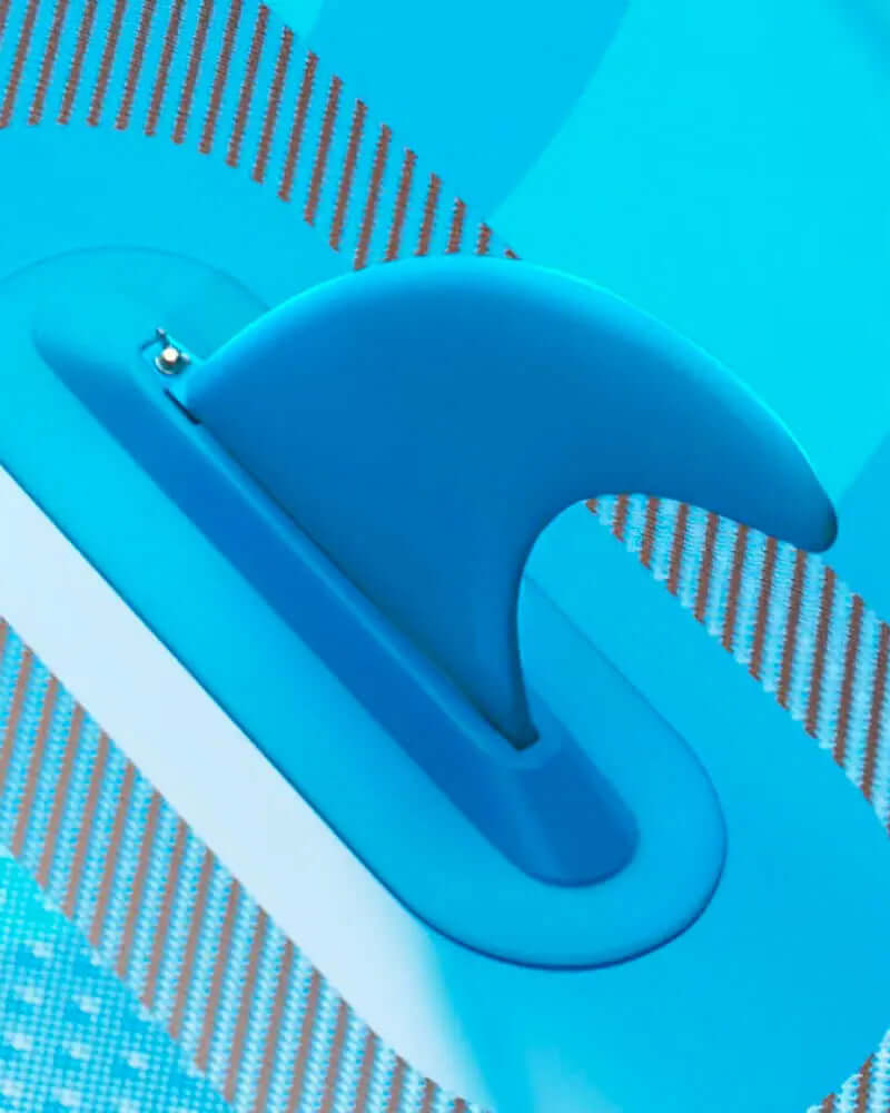 Close-up of a blue fin on an inflatable paddleboard with a textured surface.