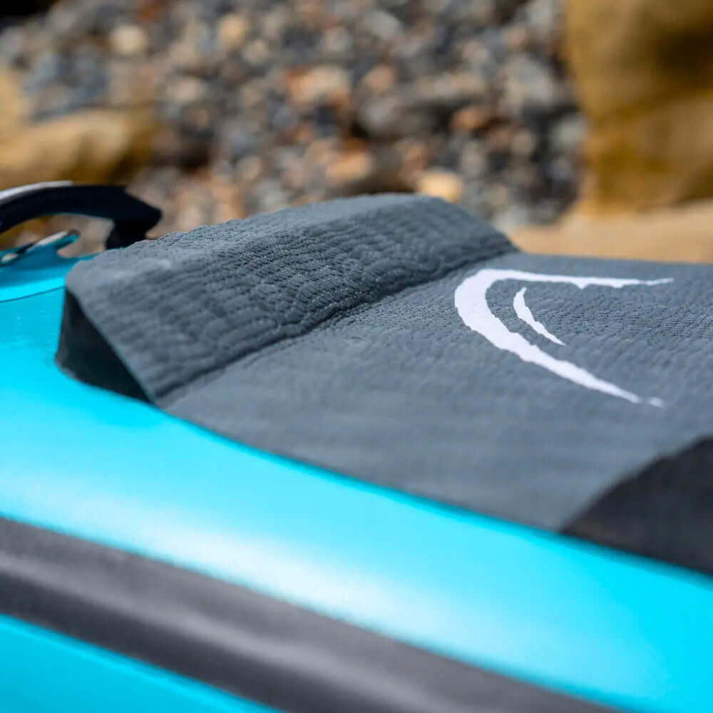 Close-up of a textured gray deck pad on a blue inflatable paddleboard with a logo