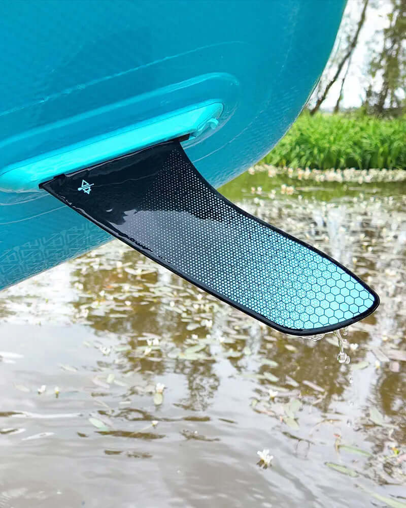 Close-up of a paddleboard's black and blue honeycomb fin above water with droplets.
