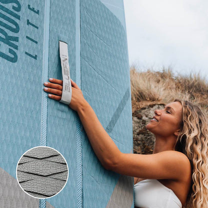 Woman holding a blue inflatable paddleboard with a textured deck and carrying strap