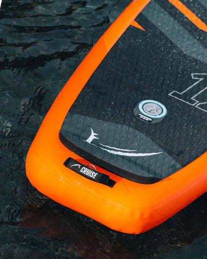 Inflatable paddleboard with orange edges, textured black deck, center fin, and valve