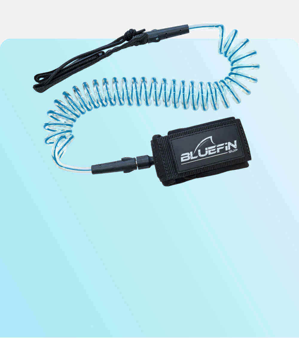 Coiled safety leash with black strap and blue cord, featuring a BLUEFIN SUP logo on the attachment.